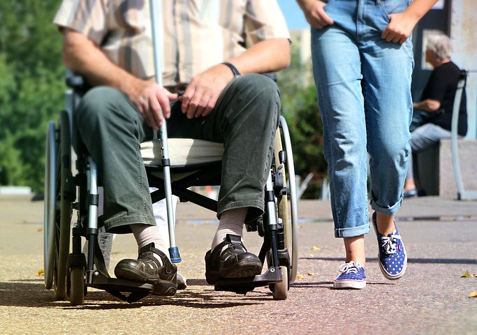 man in a wheelchair being assisted